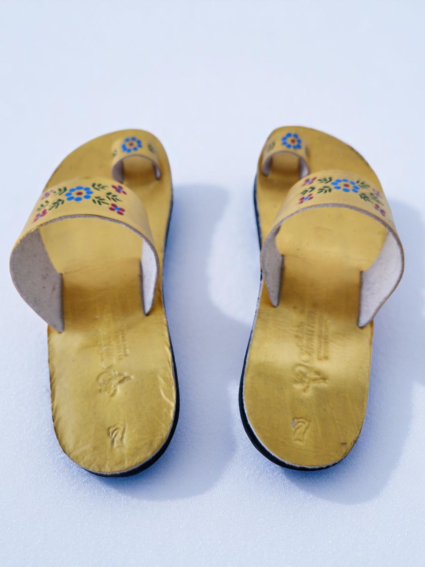 Gold color soft leather handmade toe-ring sandals with durable lightweight outsoles and hand-painted floral pattern