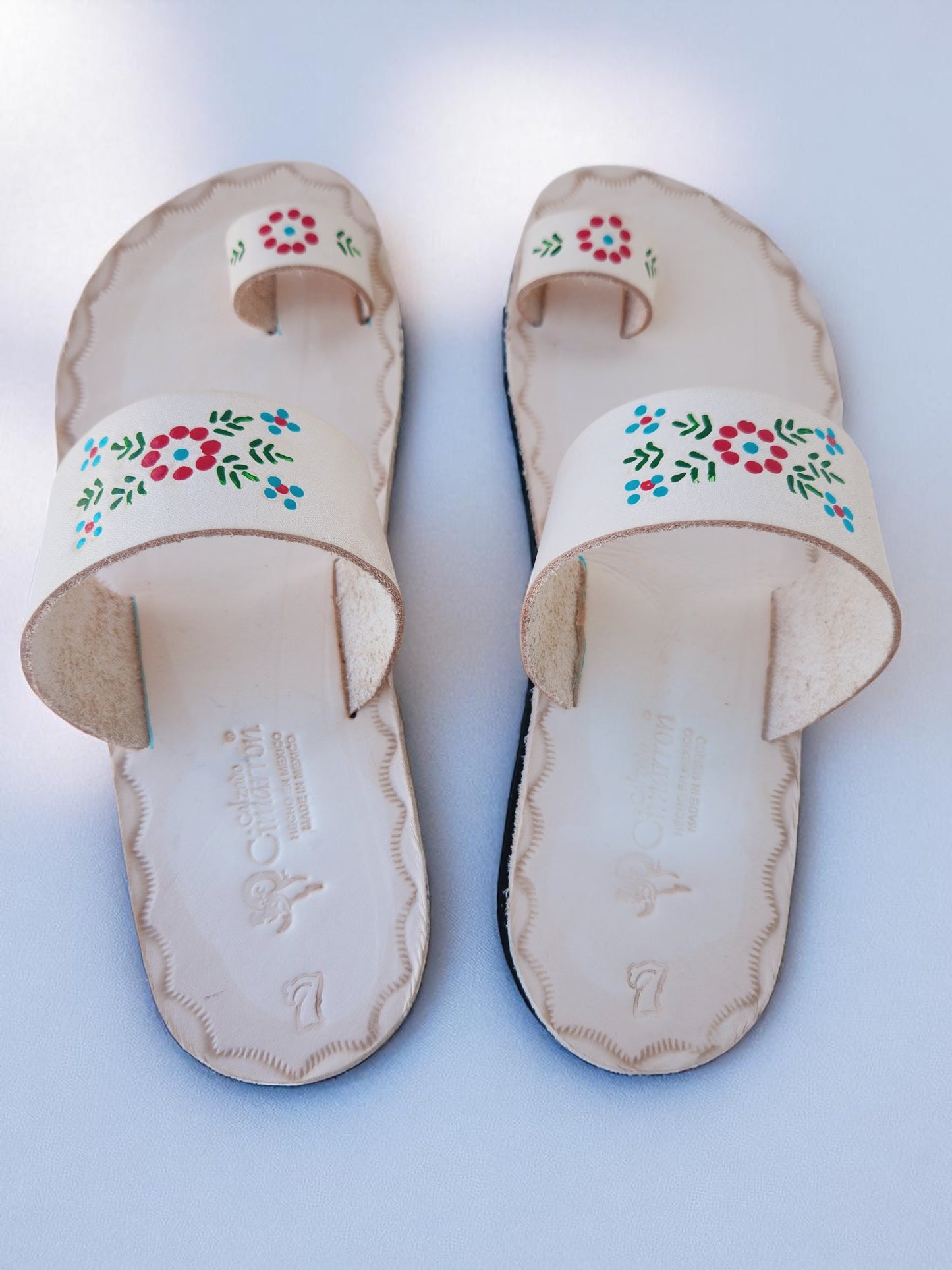 Beige soft leather handmade toe-ring sandals with  durable lightweight outsoles and hand-painted floral pattern.